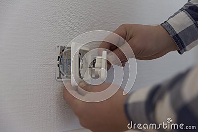 An electrician is installing contact. Home improvement Stock Photo