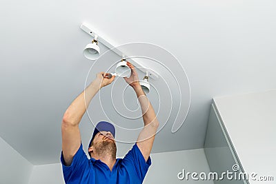 Electrician installing led light bulbs in ceiling lamp Stock Photo