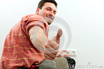 Electrician installing socket Stock Photo