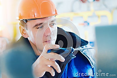 Electrician or instrumentation fitter with screwdriver adjusts operation of pressure gauge at gas industrial facility Stock Photo