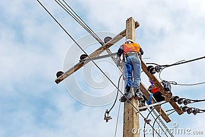 Electrician lineman repairman worker at climbing work on electric post power pole Stock Photo