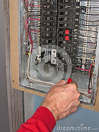 Electrician make connections in panel box Stock Photo