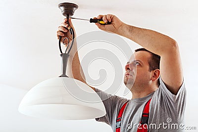 Electrician mounting ceiling lamp Stock Photo