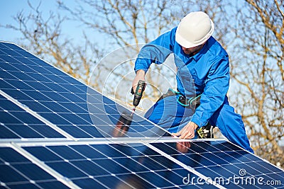 Electrician mounting solar panel on roof of modern house Stock Photo