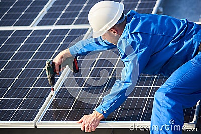 Electrician mounting solar panel on roof of modern house Stock Photo