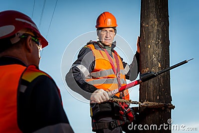 Electrician on a pole against the blue sky Editorial Stock Photo