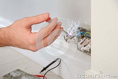 Electrician receiving electric shock while working Stock Photo