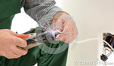 Electrician receiving electric shock while working Stock Photo