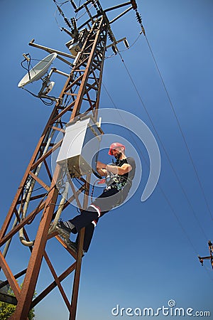 Electrician in red helmet working on SCADA antenna system Stock Photo
