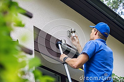 Electrician standing on ladder and change the light bulb Stock Photo