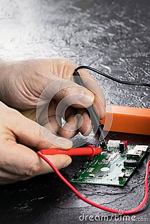 An electrician takes readings from a microcircuit using a multimeter. Measuring instruments. Copy space. Voltage Stock Photo