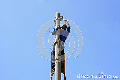 Electrician on the tower electric pole Stock Photo