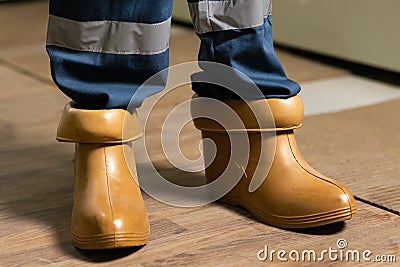 Electrician wears rubber boots for safety to avoid electric shock. Concept of electric power station development Stock Photo