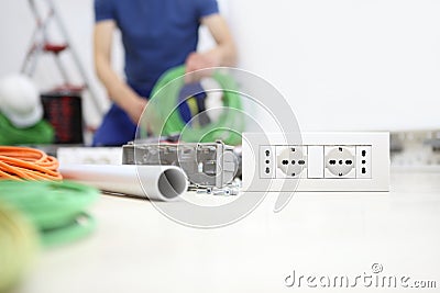 Electrician at work with bundle of cable in hand, install socket, electric circuits, electrical wiring Stock Photo