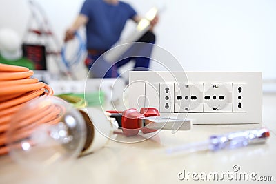 Electrician work with electrical equipment in the foreground, bulb, tools and socket, electric circuits, electrical wiring. Stock Photo