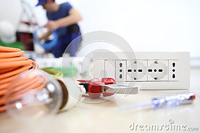 Electrician work with electrical equipment in the foreground, bulb, tools and socket, electric circuits, electrical wiring Stock Photo