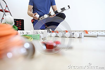 Electrician at work installing lamp, with bulb, install electric circuits, electrical wiring Stock Photo