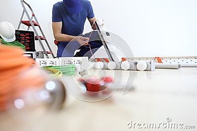 Electrician at work installing lamp, check the cable, install electric circuits, electrical wiring. Stock Photo