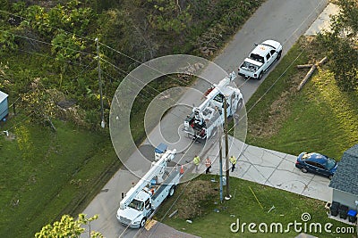 Electrician workers repairing damaged power lines using bucket trucks after hurricane Ian in Florida residential area Editorial Stock Photo