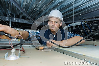 Electrician working with electric wires in factory Stock Photo