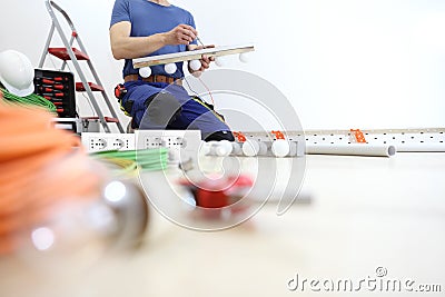 Electrician works with screwdriver installs the lamps, house electric circuits, electrical wiring Stock Photo