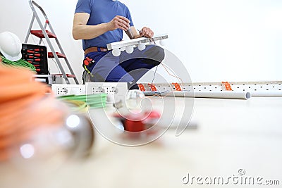 Electrician works with the screwdriver installs the lamps, house electric circuits, electrical wiring. Stock Photo