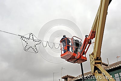 Electricians placing Christmas lights on city street Editorial Stock Photo