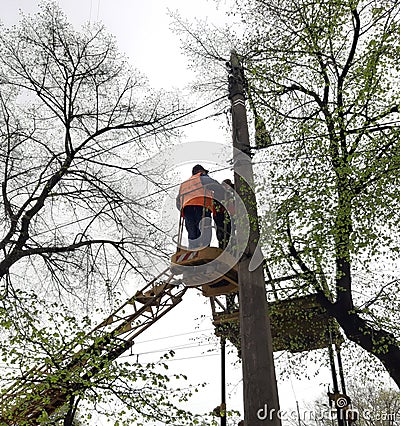 Electricians repair electrical wires. Workers carry out repair of the electrical circuit at a height. People repair wiring Editorial Stock Photo