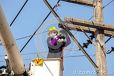 Electricians working on cable car to repair the power line Editorial Stock Photo