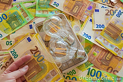 Electricity cost. light bulb on euro bills background. Rising electricity prices.Paying electricity bills. Payment for Stock Photo