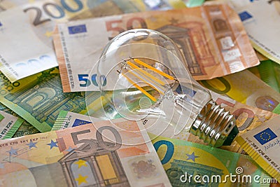 Electricity cost. light bulb on euro bills.Rising electricity prices in Europe.Crisis of energy production in the EU Stock Photo