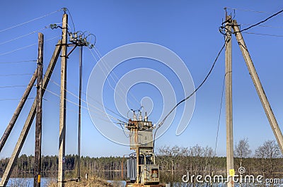 Electricity distribution transformer, electrical power substation in the countryside spring. Stock Photo