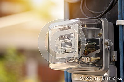 Electricity meters for home electrical appliances, including blurred natural green backgrounds. Stock Photo