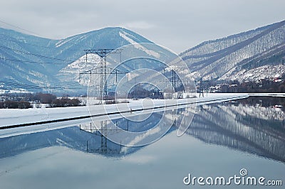 Electricity poles by water Stock Photo