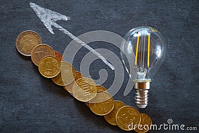 electricity prices in Europe. electricity concept.Electricity cost.Light bulb and euro coins on black chalk board.Crisis Stock Photo