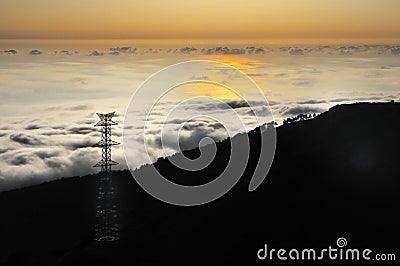 Electricity pylon over valley at sunset, Lomba das Stock Photo