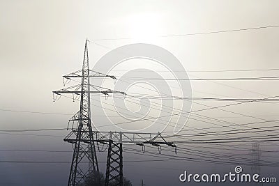 Electricity pylons from distribution power station in foggy winter freeze Stock Photo