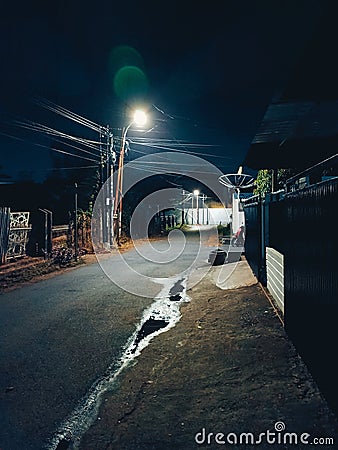Electricity pylons at night with white lights illuminating the street Stock Photo