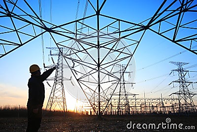 electricity workers and pylon silhouette Editorial Stock Photo