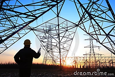 electricity workers and pylon silhouette Editorial Stock Photo