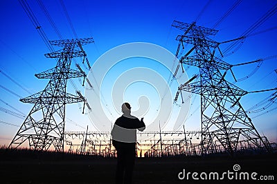 electricity workers and pylon silhouette Editorial Stock Photo