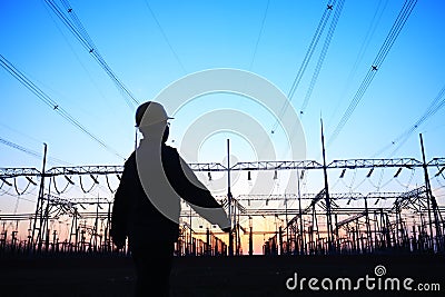 electricity workers and pylon silhouette Editorial Stock Photo