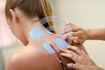 Electro stimulation in physical therapy to a young woman Stock Photo