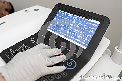 Electrocardiogram, ecg in hand, palm of a doctor. Clinic cardiology heart rhythm and pulse test closeup. Cardiogram printout. Stock Photo