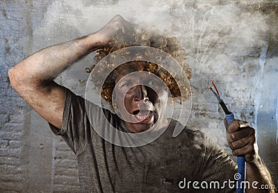 Electrocuted man with cable smoking after domestic accident with dirty burnt face shock electrocuted expression Stock Photo
