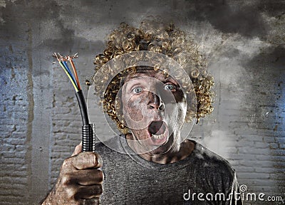 Electrocuted man with cable smoking after domestic accident with dirty burnt face shock electrocuted expression Stock Photo