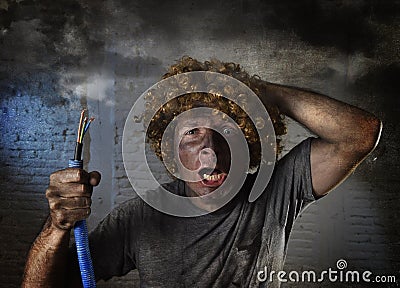 Electrocuted man with cable smoking after domestic accident with dirty burnt face shock electrocuted expression Stock Photo