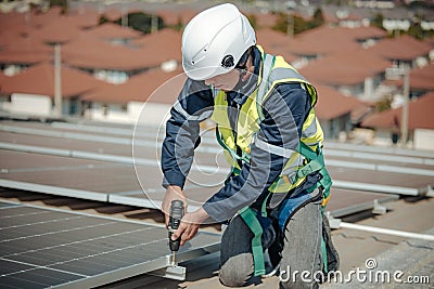 Electromechanical solar panel technician install, assemble photovoltaic systems on roof based on site assessment and schematic Stock Photo