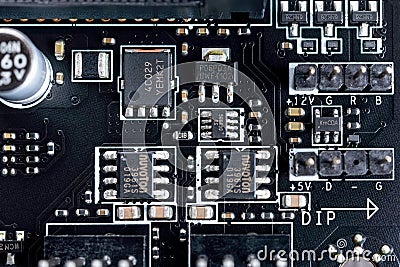 Electronic circuit board with microchips and other components on a modern black motherboard. Computer mainboard circuit components Editorial Stock Photo