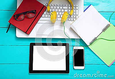 Electronic devices on blue wooden background. Headphones and work accessories. Top view and copy space Stock Photo